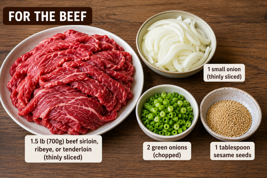 Thinly sliced beef, onion, chopped green onions, and sesame seeds arranged in bowls on a wooden surface for beef bulgogi