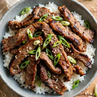 Korean beef bulgogi with grilled marinated beef slices, scallions and sesame seeds, served over steamed rice.